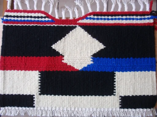 le motif géométrique en couleur de noir / écru / rouge / noir avec une partie de la bordure creuse