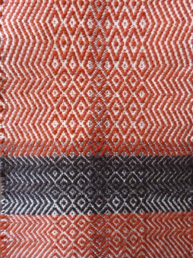 fil de trame épais couleur d'orange et de marron foncé fait apparaître les motifs chevron et losange