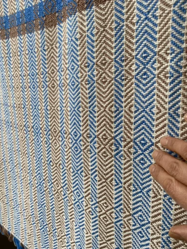plaid suspendu : motif sur des ligne blanches et des bandeaux en couleur de beige foncé et de bleu