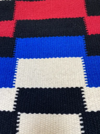 Le motif des rectangles sont graduels et chaque couleur suit horizontalement en passant sur l'autre couleur comme une vague