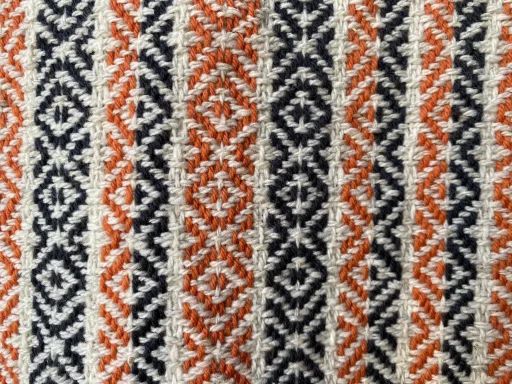 motif losanges sur des lignes fines en couleur écru et sur des bandeaux noir et rouge